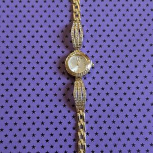 Дамски кварцов часовник с метален корпус, украсен с блестящи камъни и фини детайли, стилен и елегантен аксесоар.