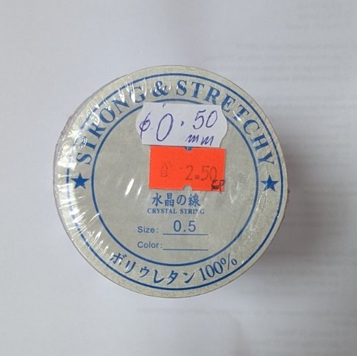 Прозрачна еластична корда Strong & Stretchy 0.50 мм, опакована в кръгла кутия с надписи на японски и английски език.